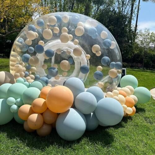 an inflatable bubble ball sitting on top of a lush green field