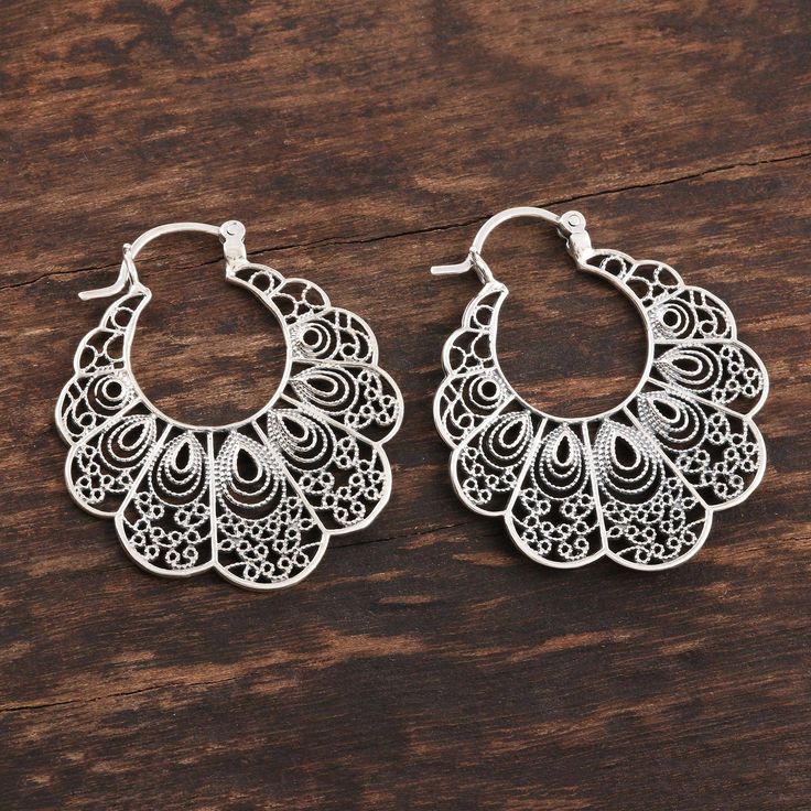 These lacy filigree hoop earrings are the design of Neetu Barathi in India. The earrings are crafted of sterling silver and feature delicate wirework within their scalloped forms. Luxury Oval Filigree Earrings, Filigree Design Jewellery, Ornate Sterling Silver Hoop Earrings With Intricate Design, Handmade Ornate Hoop Earrings, Ornate Handmade Hoop Earrings, Ornate Silver Hoop Earrings With Intricate Design, Small Hoop Sterling Silver Filigree Earrings, Elegant Festival Hoop Earrings With Intricate Design, Small Sterling Silver Filigree Hoop Earrings