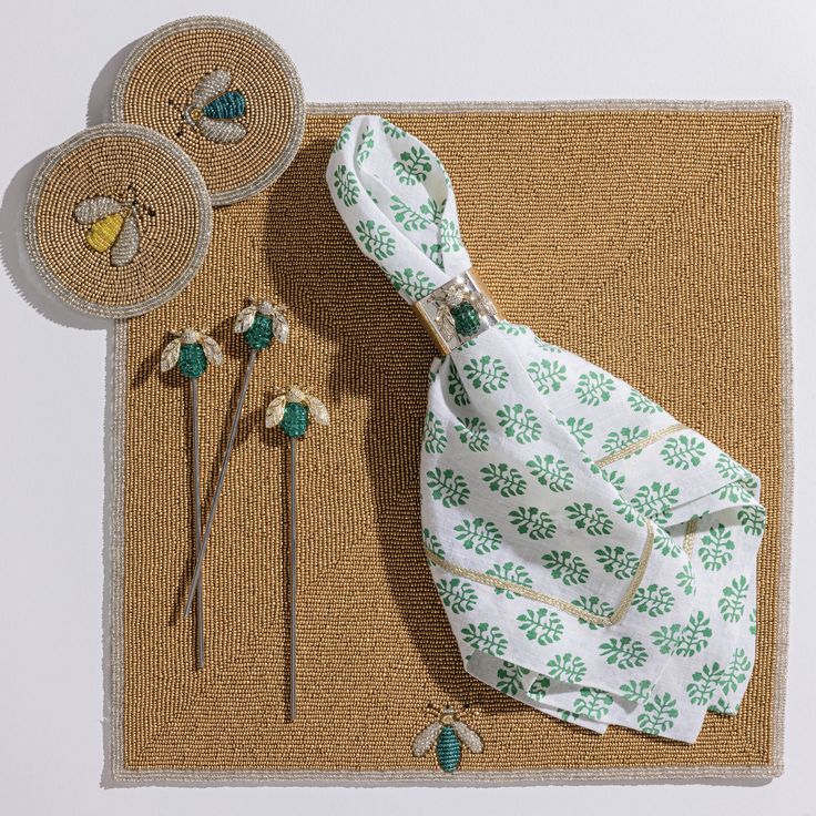 an assortment of sewing supplies on a mat with pins and needles in the shape of flowers