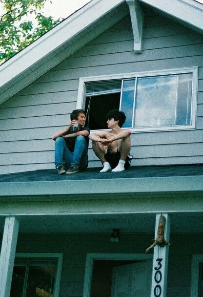 two people sitting on the roof of a house