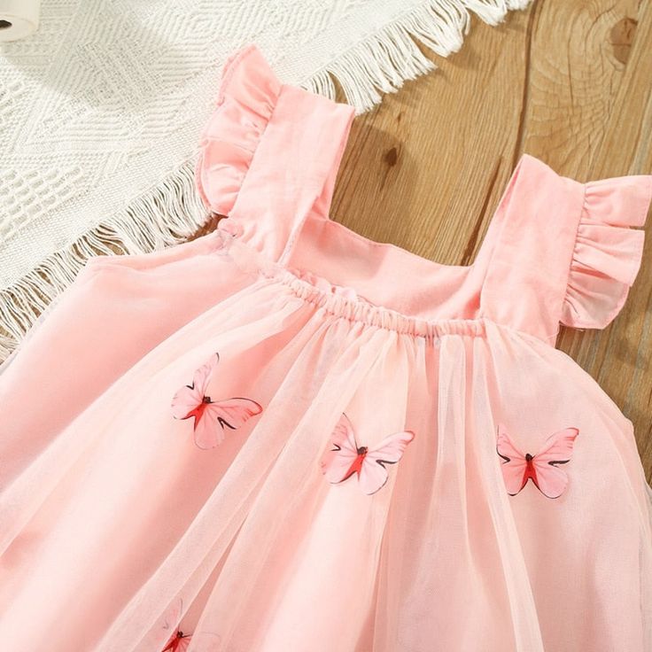 This BUTTERFLY Tulle Summer Dress is the perfect choice for any special occasion. The butterfly application on the tulle overlay creates a beautiful look that is sure to turn heads. Perfect for those warm summer months, this dress will keep your little one cool and stylish all summer long. Pink Fairy Dress For Summer Dress-up, Summer Princess Style Fairy Dress, Summer Pink Tulle Tutu Dress, Sleeveless Tulle Princess Dress For Summer, Sleeveless Summer Tulle Princess Dress, Playful Pink Fairy Dress For Summer, Cute Summer Fairy Dress For Dress-up, Playful Fairy Dress For Dress-up In Summer, Playful Summer Tutu Dress With Tulle Skirt