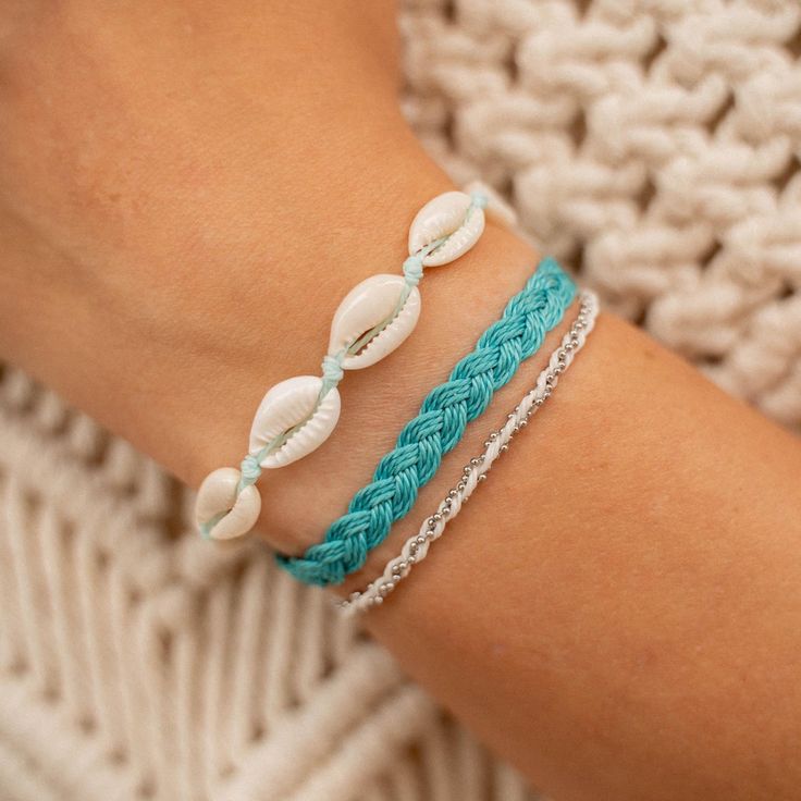 CORON BEACH BRACELET SET  Embrace the beauty of the ocean with our Coron Beach Bracelet Set. Crafted with ocean tones, this set will bring a touch of the sea to your everyday look. The perfect set of 3 bracelets for any beach lover! - Made with natural cowrie shells, a dainty silver chain, soft nylon cord and our durable wax polyester cord. - Bracelets measure approx. 17cm with a 7cm sliding knot extension on each side. - Handmade in Bali. - Biodegradable or recycled packaging. OTHER INFORMATION Vacation Strand Bracelets With Sliding Knot, Beach Friendship Bracelets With Sliding Knot, Ocean-inspired Bracelets For Beach Season, Bohemian Braided Strand Bracelets For Vacation, Bohemian Strand Braided Bracelets For Vacation, Bohemian Braided Strand Bracelet For Vacation, Coastal Jewelry For Beach Party, Turquoise Braided Bracelets For Summer Gifts, Turquoise Braided Bracelet For Summer Gift