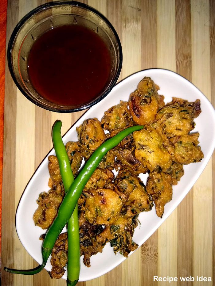 a white plate topped with fried food next to a bowl of sauce and green beans