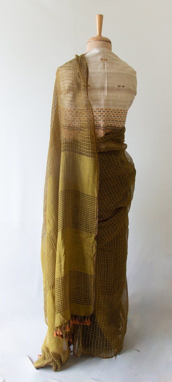 A beautifully woven handloom saree from our looms in Assam , India.  The saree has mulberry noil silk in the warp and weft and woven in chequered pattern that is locally known as 'gari diya ' or transparent checks. That makes the saree extremely lightweight , weighing appx around 200 gms .  The Saree has been natural dyed post weaving using onion peels. Traditionally these kinds of transparent checks were woven in raw mulberry silk or in cottons.  The Saree  has a plain blouse piece dyed same gr Saree Outfit, Simple Saree Designs, Saree Jewellery, Handloom Weaving, Dress Neck, Simple Sarees, Fancy Blouse, Exotic Fish, Saree Models