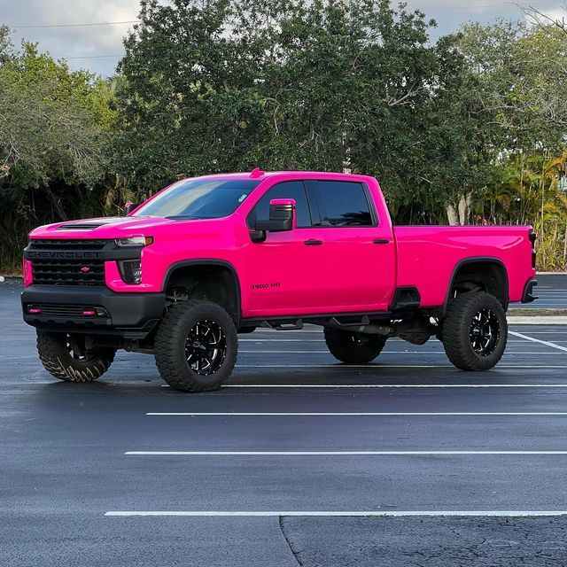 a bright pink truck parked in a parking lot