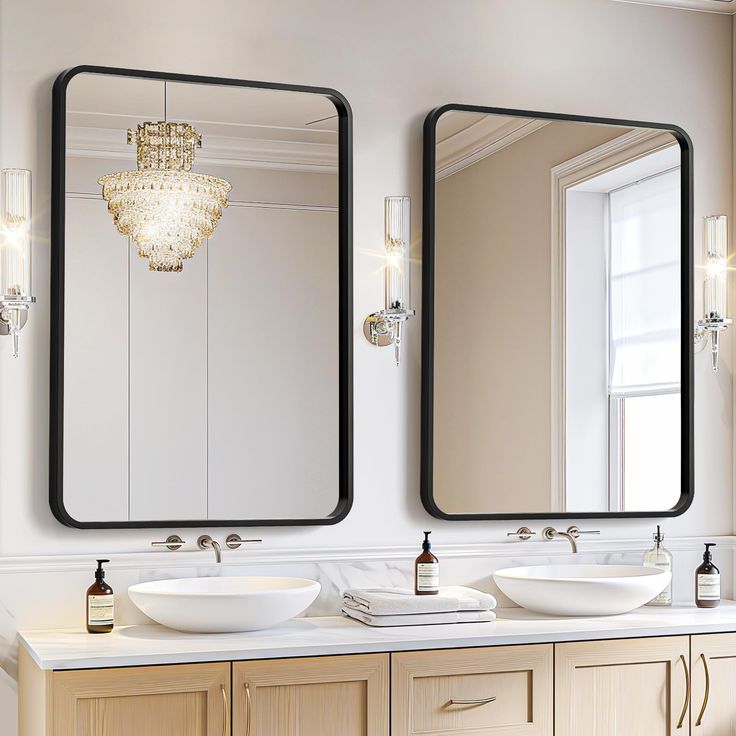 two bathroom sinks with mirrors and lights above them