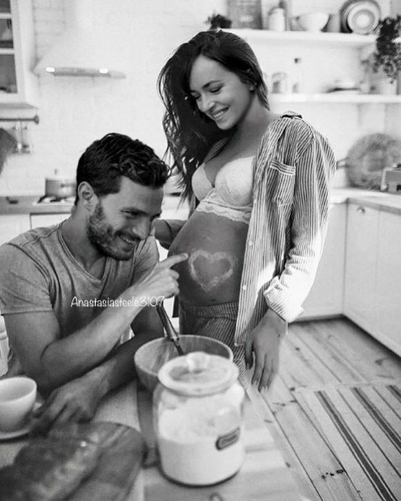 a man and woman are preparing food in the kitchen, one is holding a spoon