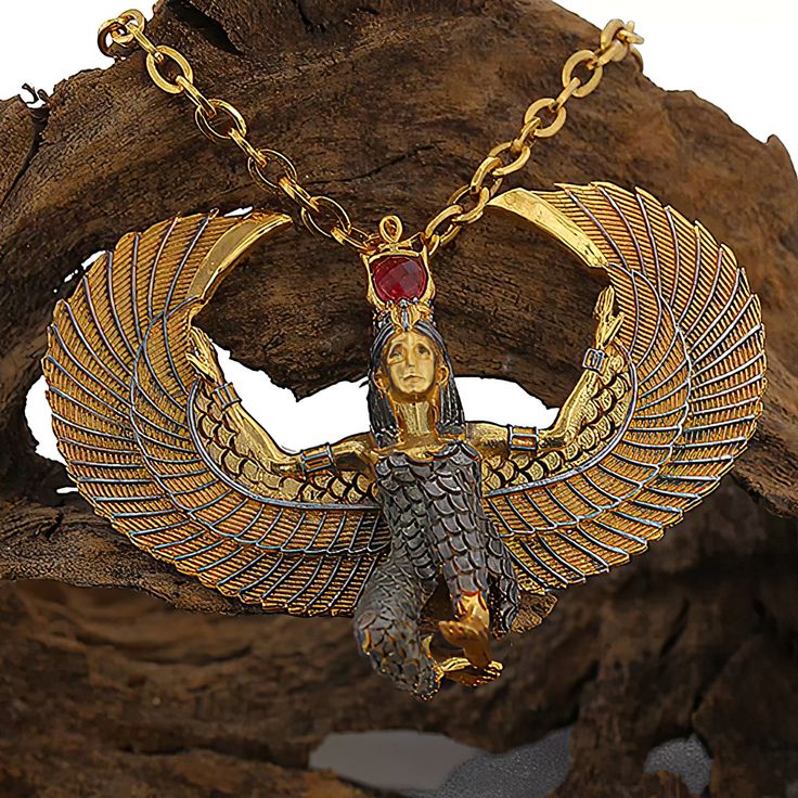 an egyptian necklace with gold and red stone in the shape of an owl on a chain