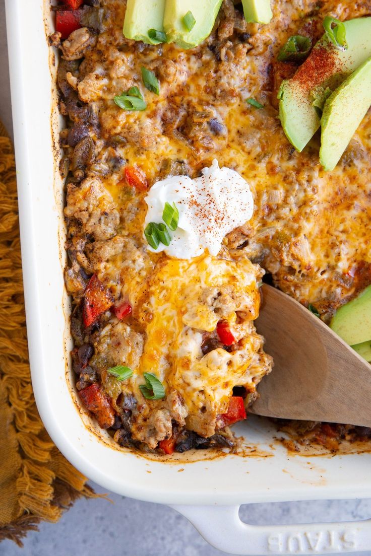 an enchilada casserole with meat, cheese and avocados