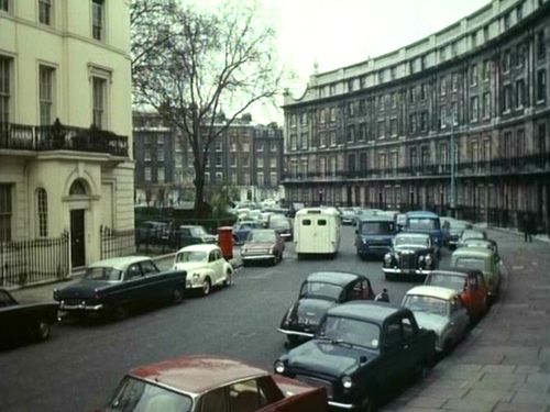 cars are parked on the street in front of buildings