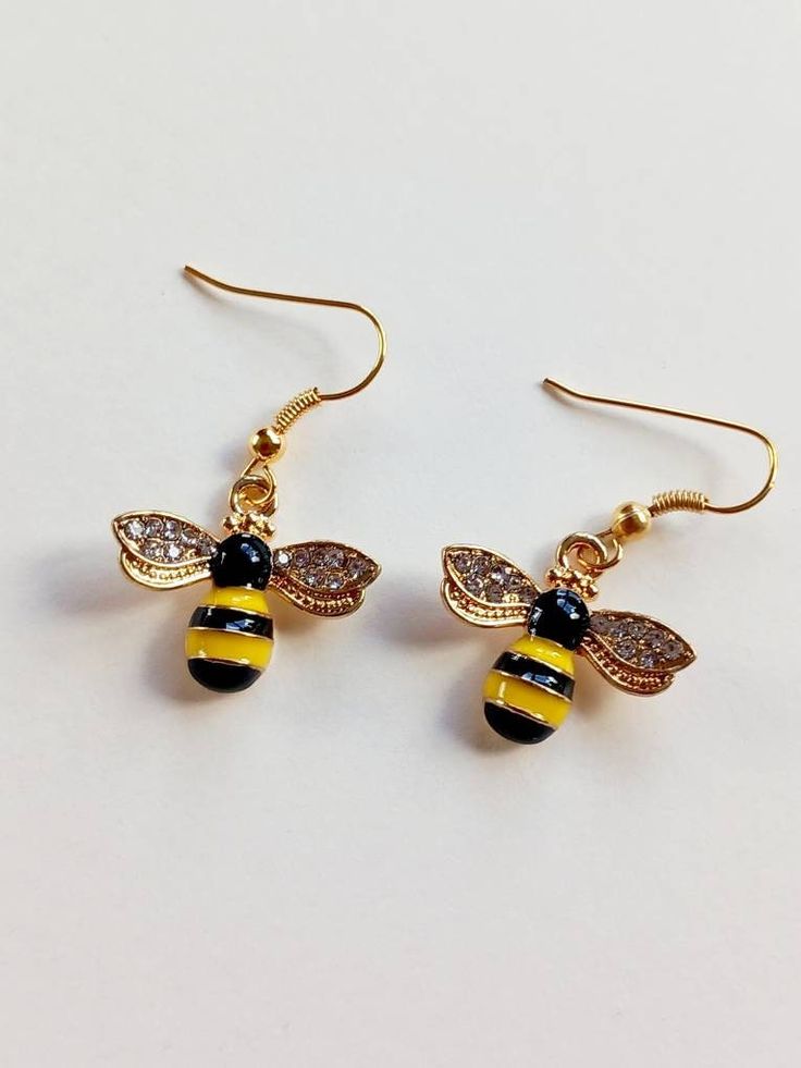 Honey bee dangly charm earrings with clear diamanté wings, in gold plated metal. The bee charms are approx.  20 mm x 20 mm and hangs approx 35 mm from your earlobe. Gift bag included. Would make a great Christmas jewellery piece, a secret santa or a gift for yourself. Bee Jewellery, Christmas Jewellery, Bee Keeper, Bee Jewelry, Bee Gifts, Bee Charms, Jewellery Gold, Dangly Earrings, Christmas Jewelry