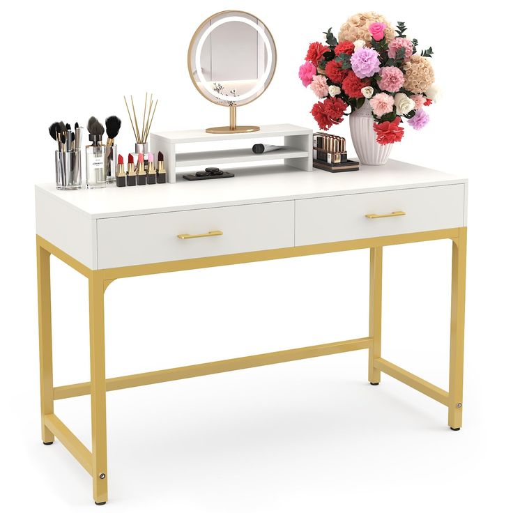 a white desk with flowers and makeup on it, next to a mirror that has a gold frame