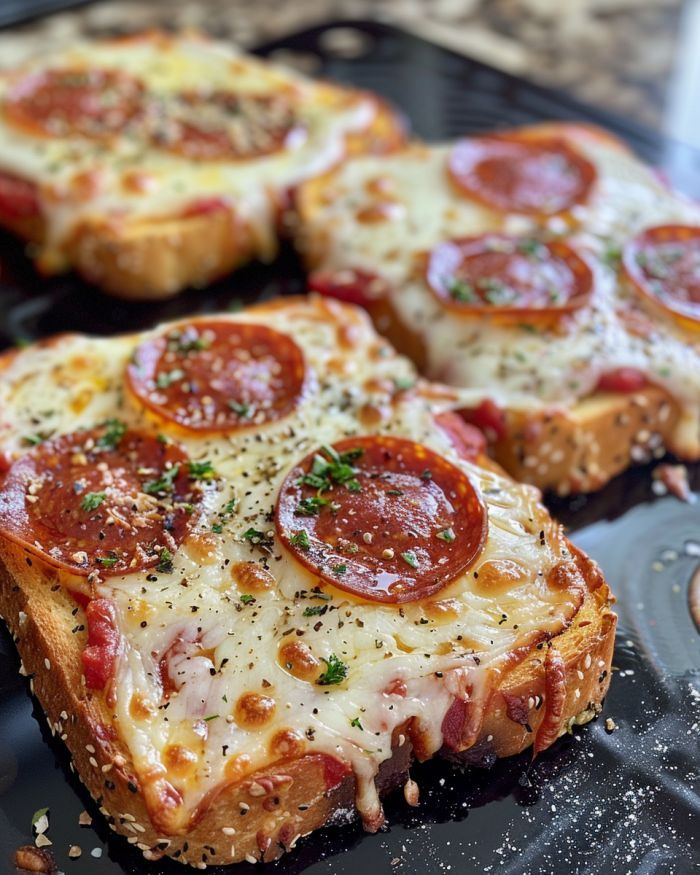 slices of pepperoni pizza sitting on top of a black plate