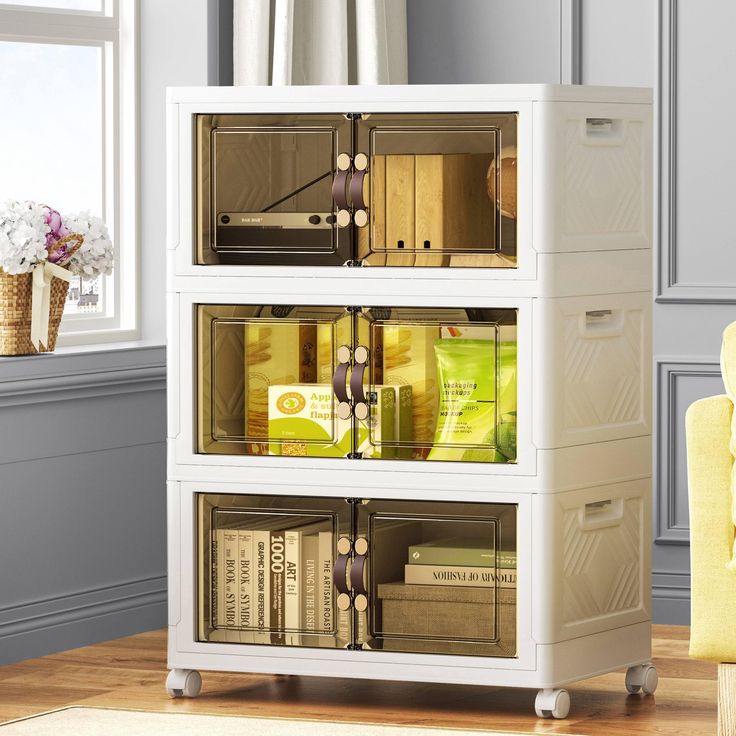 a white bookcase filled with lots of books on top of a hard wood floor