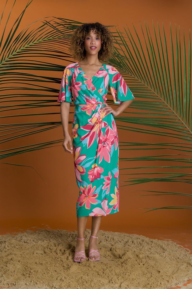 Stay stylish this summer in our Romilly dress with a v-neck, flutter sleeves, and a beachy floral print. The faux wrap design and midi length make it perfect for any summer occasion. Tropical V-neck Dress With Vibrant Print, Summer Multicolor Midi Dress With Surplice Neckline, V-neck Tropical Dress With Vibrant Print, Chic V-neck Midi Dress With Tropical Print, Green Floral Beach Dress With Short Sleeves, Multicolor Tropical Print V-neck Floral Dress, Multicolor V-neck Floral Dress With Tropical Print, Green Short Sleeve Floral Dress For Beach, Green Flutter Sleeve Summer Dress