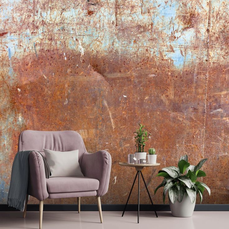 two chairs and a table in front of a rusted wall