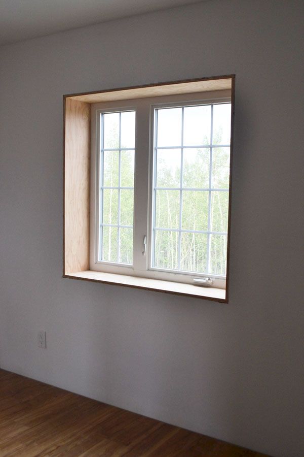 an empty room with wood floors and a large window in the corner on the wall