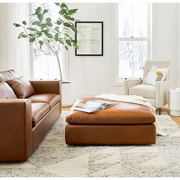 a living room filled with furniture and a tree in the middle of the room on top of a rug