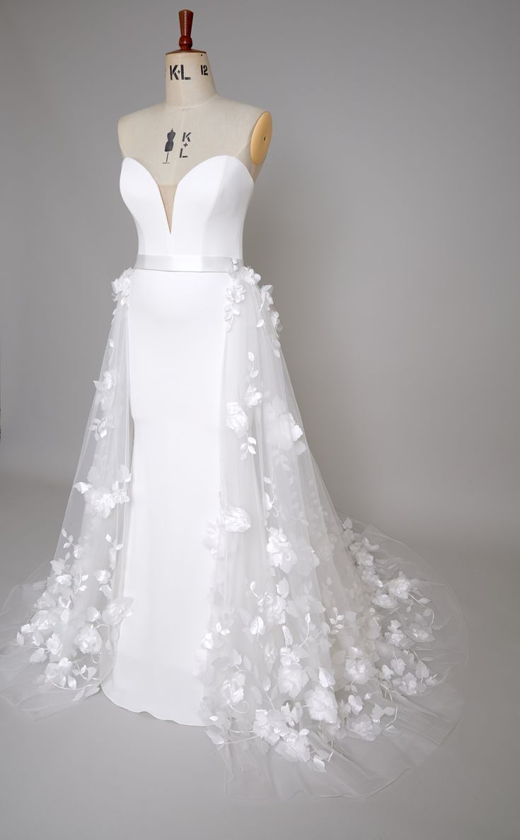 a white wedding dress with flowers on it