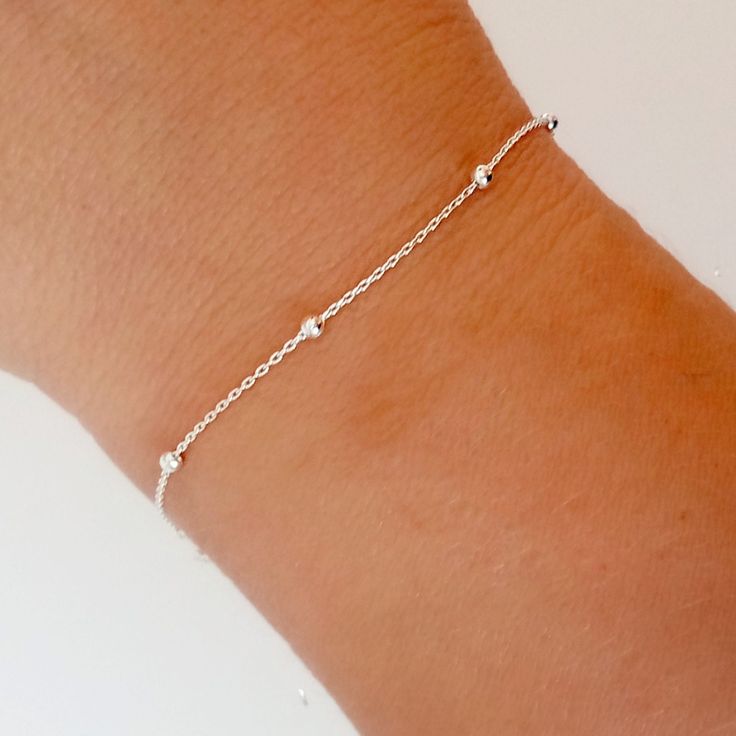 Minimalist style bracelete with inserted balls, made of Sterling Silver.  This is a very simple and elegant women's bracelet, made of 925 Sterling Silver, ideal for day to day.  This bracelet is ideal to put it on and not take it off. It fits very tight on the wrist, usually without being too tight.  It's 16cm long and doesn't have an extension, so it's a good idea to measure your wrist to make sure it fits perfectly. Would you like to have the version of this bracelet in silver with gold platin Dainty Sterling Silver Bracelet With Satellite Chain, Sterling Silver Bracelets With Satellite Chain, Minimalist Sterling Silver Satellite Chain Bracelet, Silver Minimalist Satellite Chain Bracelet, Minimalist Silver Satellite Chain Bracelet, Eco Friendly Stores, Women In India, 925 Silver Bracelet, Ball Bracelet