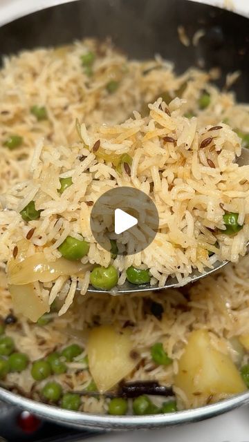 a pan filled with rice and peas on top of a stove