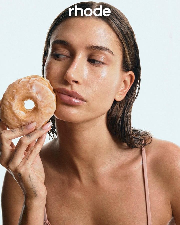 a woman holding a donut in her right hand