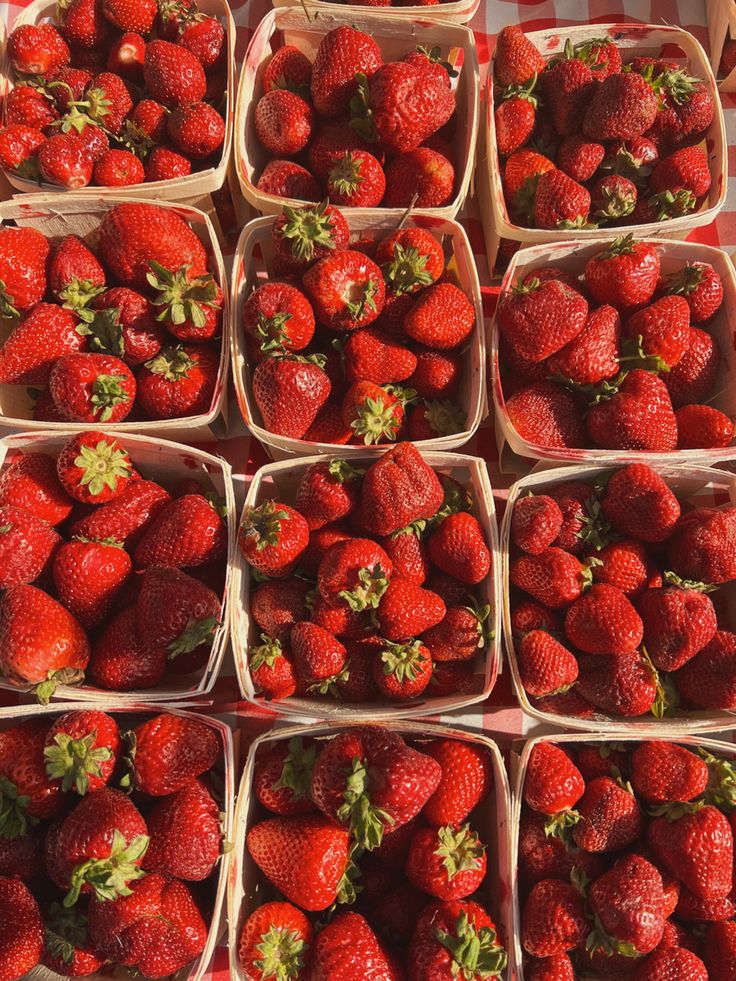 many baskets of strawberries are stacked on top of each other