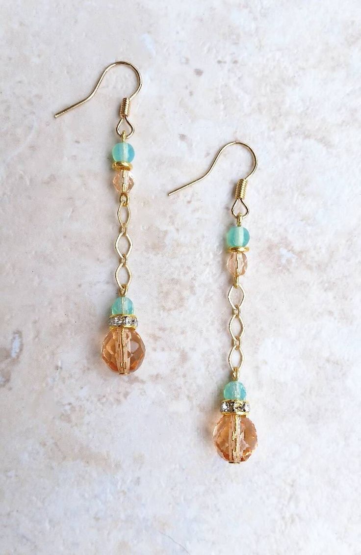 "Translucent peach and milk sea green Czech glass beaded satin gold chain drop earrings with crystal rhinestone gold spacers A little bit peachy and a little bit beachy, these simple and versatile drop earrings are the perfect summer accessory! Whether you're going to a movie in the park or a wedding on the beach, their classic minimalist design make these earrings both versatile and elegant. From a gold plated earwire hangs 4mm milky sea green and faceted pink Czech glass beads separated by a bright golden brass spacer bead.  From these beads dangle an 8mm faceted translucent peach and a 4mm faceted seafoam green Czech glass bead on a satin gold diamond link chain. A 5mm gold plated crystal rhinestone spacer separates the two focal beads and adds just enough sparkle to make these simple b Trendy 14k Gold Filled Dangle Jewelry, Trendy 14k Gold-filled Dangle Jewelry, Wire Wrapped Czech Glass Drop Earrings, Dainty Dangle Beaded Earrings, Gold Dangle Earrings With Beaded Chain, Dainty Dangle Beaded Earrings With Ear Wire, Adjustable Gold Earrings With Beaded Chain, Rose Gold Beaded Drop Earrings, Dainty Beaded Drop Earrings