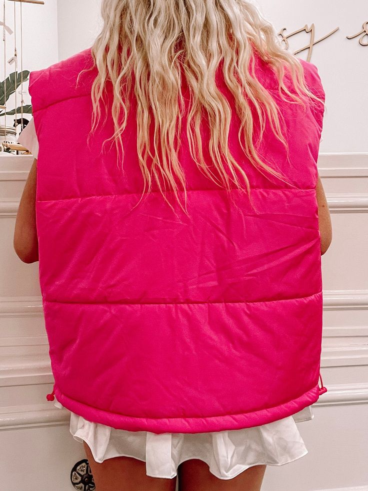 Our Polly Pocket is a hot pink down vest. She features adorable a front snap button closure, and front pockets. content: 100% polyester care: hand wash, lay flat to dry Spring Nylon Vest With Pockets, Trendy Winter Vest With Button Closure, Trendy Nylon Spring Vest, Trendy Spring Nylon Vest, Trendy Nylon Vest For Spring, Pink Vest Outerwear For Spring, Casual Pink Vest Outerwear, Pink Sleeveless Outerwear For Fall, Casual Pink Sleeveless Outerwear