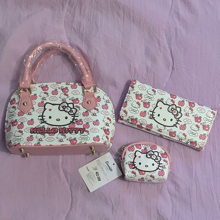 two hello kitty purses on a bed