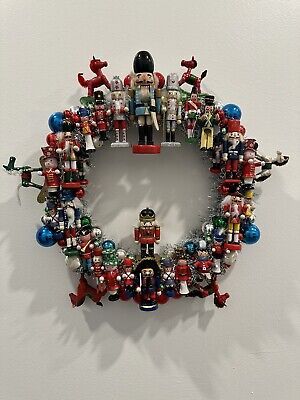 a christmas wreath made out of legos and ornaments on a wall with white background