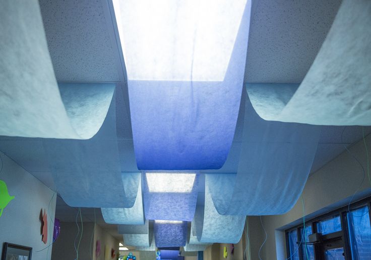 a hallway with blue and white curtains hanging from the ceiling