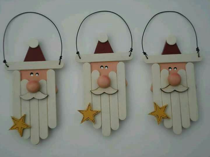 three wooden santa claus ornaments hanging on the wall with star decorations attached to each piece