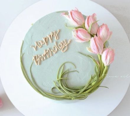 a birthday cake decorated with pink flowers and the words happy birthday written in frosting