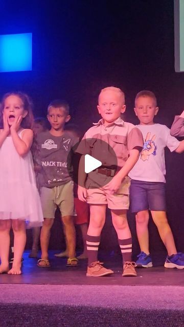 children stand on stage with their mouths open