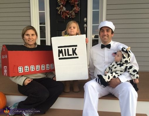 two adults and a child are sitting on the front porch holding signs that read milk