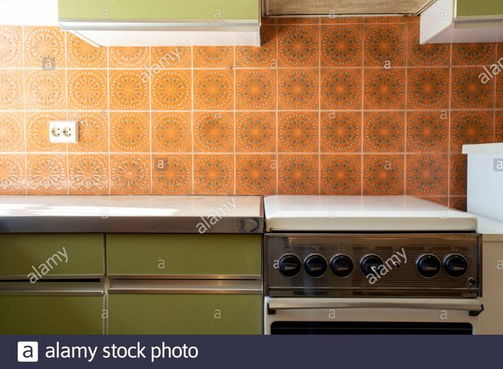 a kitchen with green and orange tiles on the backsplash, stove and oven