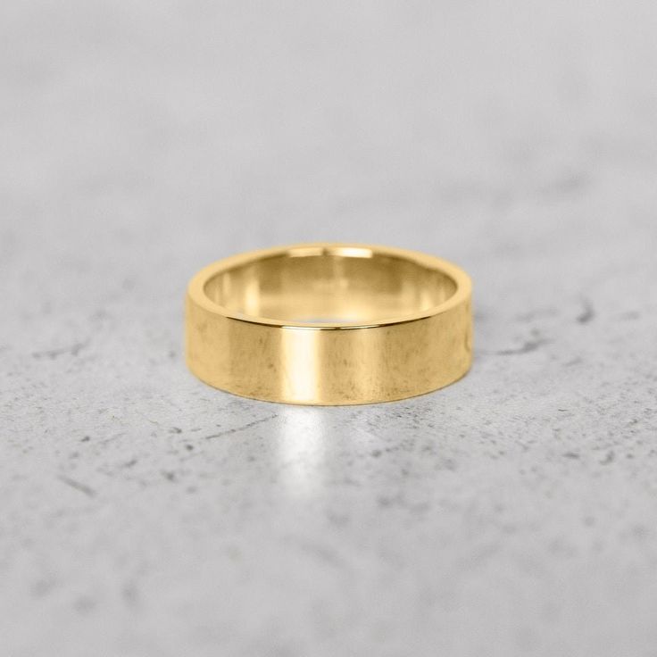 a gold wedding ring on a gray surface