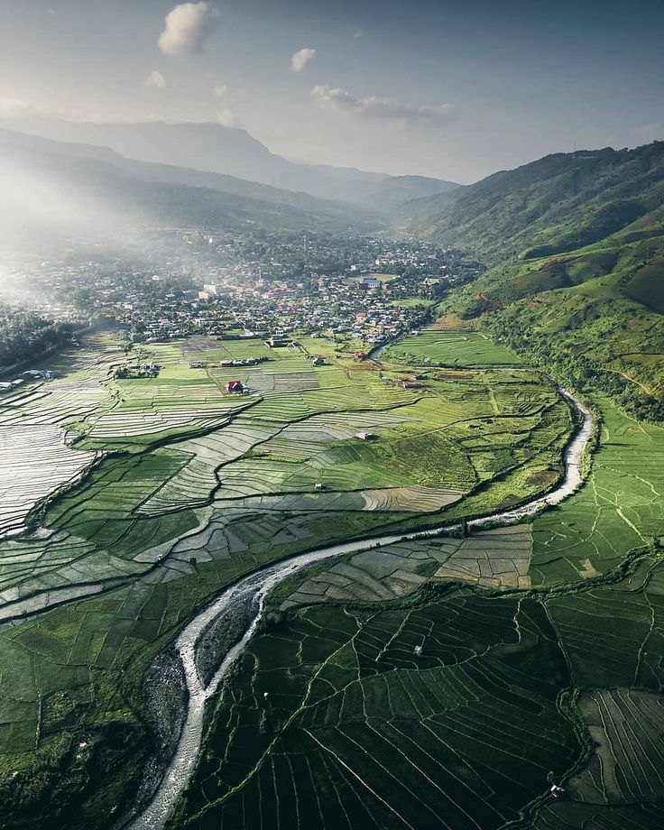 an aerial view of a river running through a lush green valley