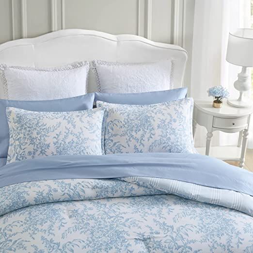 a bed with blue and white comforters in a bedroom