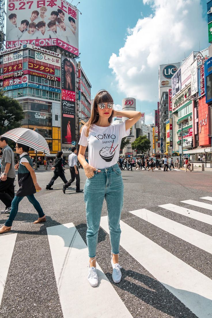 a woman standing in the middle of a cross walk