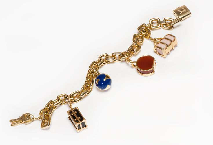 Louis Vuitton Gold Charm Bracelet.Chain bracelet with padlock, globe and luggage charms crafted in 18K yellow gold by Louis Vuitton from 2000 Collection. Semi-precious stones, carnelian, onyx, white coral and blue enamel. Bracelet will fit up to a 7.5 inches wrist. Weight 150 Grams. This Louis Vuitton bracelet is highly collectable! Padlock keys and charms with LV monogram and French hallmarks which are stamped on most of its products, like watches, jewelry, accessories etc. Louis Vuitton is one Luxury Charm Bracelet With Logo, Luxury Charm Bracelet With Logo Charm As Gift, Luxury Logo Charm Bracelet As Gift, Luxury Chain Charm Bracelet For Formal Occasions, Luxury Yellow Gold Charm Bracelet With Logo, Luxury Formal Bracelets With Charms, Luxury Chain Charm Bracelet For Gift, Luxury Gold-tone Chain Charm Bracelet, Gold-tone Chain Luxury Charm Bracelet