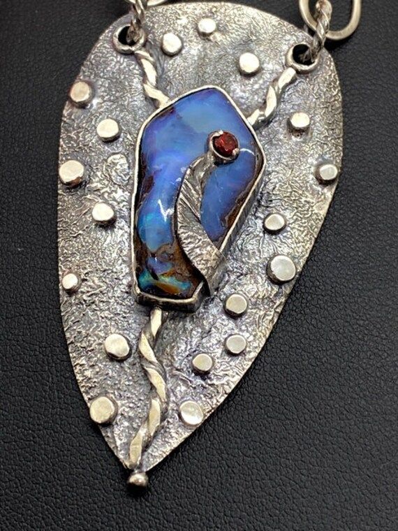 "Australian Boulder Opal gemstone pendant in sterling silver Hand-made Sterling Silver 925 Stones used: Australian Opal, Garnet Height -2 1/2\", Width - 1 3/8\" Unique Handcrafted One-of a-kind Design Pendant Each Piece of Jewelry in my Collection is Absolutely One of a Kind! When you start wearing a piece of my jewelry you will fall in love with it more and more each day and feel that good Energy and Love that I pass into it while creating this piece of Art. A piece of Art created for you to be Unique Teardrop Hallmarked Necklace, Unique Teardrop Necklace With Hallmark, Artistic Hand Forged Sterling Silver Jewelry, Unique Hallmarked Teardrop Necklace, Artistic Sterling Silver Jewelry With Gemstones, Artistic Sterling Silver Necklace With Polished Finish, Artisan Pendant Jewelry With Polished Finish, Unique Teardrop Pendant Jewelry For Anniversary, Unique Polished Finish Necklace For Anniversary