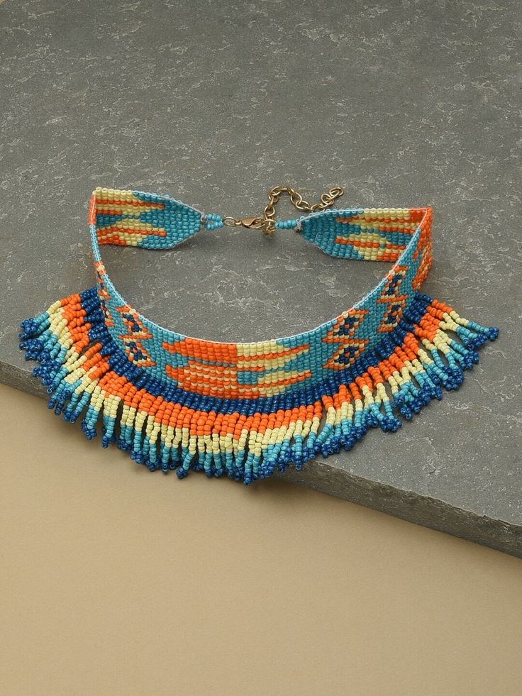 Blue and orange choker necklace Material and stone type: alloy with artificial beads Closure: lobster closure Care Instructions: Wipe your jewellery with a soft cloth after every use Always store your jewellery in a flat box to avoid accidental scratches Keep sprays and perfumes away from your jewellery Do not soak your jewellery in water Dispatch within 7 days Festival Blue Beaded Necklaces With Colorful Beads, Blue Beaded Necklaces For Festivals, Traditional Blue Beaded Choker, Bohemian Blue Beaded Necklace, Traditional Blue Choker With Colorful Beads, Traditional Blue Beaded Choker Necklace, Adjustable Orange Jewelry For Festivals, Blue Round Bead Necklaces, Blue Round Bead Necklaces As Fashion Accessory