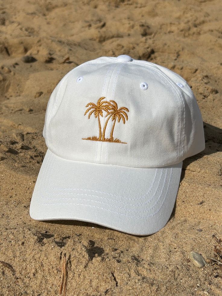 "🌴☀️ Calling all summer enthusiasts! 🌊🕶️ Feast your eyes on our Summer Vibe Hat - it's like wearing a mini tropical vacation on your head! 🏝️😎 📍About product📍 * 100% chino cotton twill * Green Camo color is 35% chino cotton twill, 65% polyester * Unstructured, 6-panel, low-profile * 6 embroidered eyelets * 3 ⅛\" (7.6 cm) crown * Adjustable strap with antique buckle 📦 Shipping & Handling Times * Domestic: Kindly allocate approximately 2-7 business days for order processing, followed by an Cheap Beach Hats With Embroidered Logo, Casual Summer Hats For Adventures, Beach Cotton Baseball Cap, Summer Travel Hat With Curved Bill, White Visor Trucker Hat For Beach, White Casual Snapback Hat For Travel, White Snapback Hat For Travel, White Adjustable Baseball Cap For Travel, Casual Curved Brim Hat For Summer Adventures