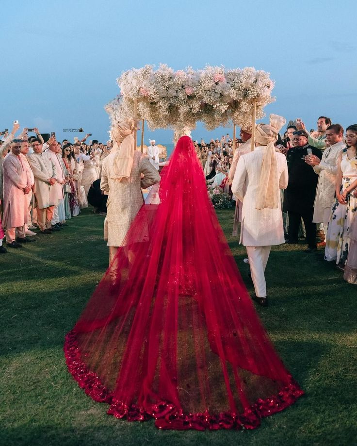 From bride's beautiful self-design red lehenga to exquisite baby breaths phoolon ki chaddar, from her dupatta trail to bridesmaids' twinning outfits, from her dream bridal entry to breathtaking varmala photos, there's nothing not to love about this gorgeous bride Thailand wedding 😍 Taf a friend who is getting married soon and share this dreamy wedding inspiration with them. Couple: @kashtag90 @jhalakshah_ Planner: @krish_events Venue: @avanihuahin Decor: @dp_designbypeerapach Light and So... Indian Bride Veil Red, Lehenga Veil Indian Bridal, Indian Bride Wedding Outfits, Indian Wedding Bride Entry, Minimalist Bride Indian, Varmala Photos, Phoolon Ka Chaddar, Wedding Lehnga Bridal Lehenga, Red Lehenga Bride