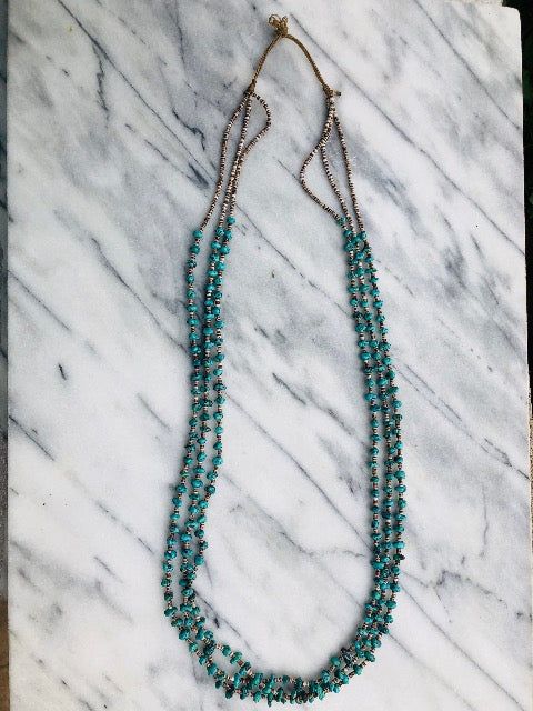 3 Strands of Genuine Heishi and Turquoise Necklace done on traditional threading and no clasp needed. Material: 3 mm, New Mexico turquoise nugget, tiny Heishi (shell beads). Length: 32 inches. Layer with a combo of other necklaces for a hobo chic vibes. (shown in photo) Turquoise Multi-strand Jewelry With Tiny Beads, Artisan Multi-strand Jewelry With Tiny Beads, Artisan Tiny Turquoise Beads, Bohemian Lariat Necklace With Tiny Beads, Turquoise Multi-strand Tiny Beads Necklace, Turquoise Multi-strand Beaded Necklaces With Tiny Beads, Turquoise Multi-strand Tiny Beads, Turquoise Multi-strand Beaded Necklaces, Turquoise Hand-strung Lariat Jewelry