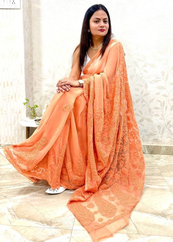 "Dusky orange hand Embroidered Chikankari Saree with Blouse piece | Georgette Saree | Chikankari work / Chikankari saree/ Party wear saree Wedding wear saree, party wear saree, chikankri hand work saree, hand embroidered saree, hand work saree. This is authentic hand embroidered chikankari Saree. The unique thread embroidery design is entirely handcrafted by our skilled artisans. The most significant aspect of hand embroidery is the stitch pattern. The running blouse piece is included with this fine quality chikankari georgette saree. Saree Length : 5.5 mtr Blouse Piece Length : 0.8 mtr Weight : 500 gm approx Design : Hand chikankari embroidery Work The fabric is best quality georgette.  Wash care - Dry clean first time and then soft hand wash. SLIGHT DIFFERENCE IN SHADE MIGHT APPEAR DUE T Eid Anarkali Pre-draped Saree With Pallu, Festive Semi-stitched Pre-draped Saree For Puja, Bollywood Style Floor-length Saree With Pallu, Embroidered Blouse Piece For Saree In Georgette, Embroidered Georgette Blouse Piece For Saree, Semi-stitched Georgette Pre-draped Saree With Self Design, Chinon Blouse Piece For Eid, Eid Puja Pre-draped Saree With Resham Embroidery, Unstitched Orange Pre-draped Saree For Puja