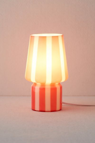 an orange and white striped lamp on a table