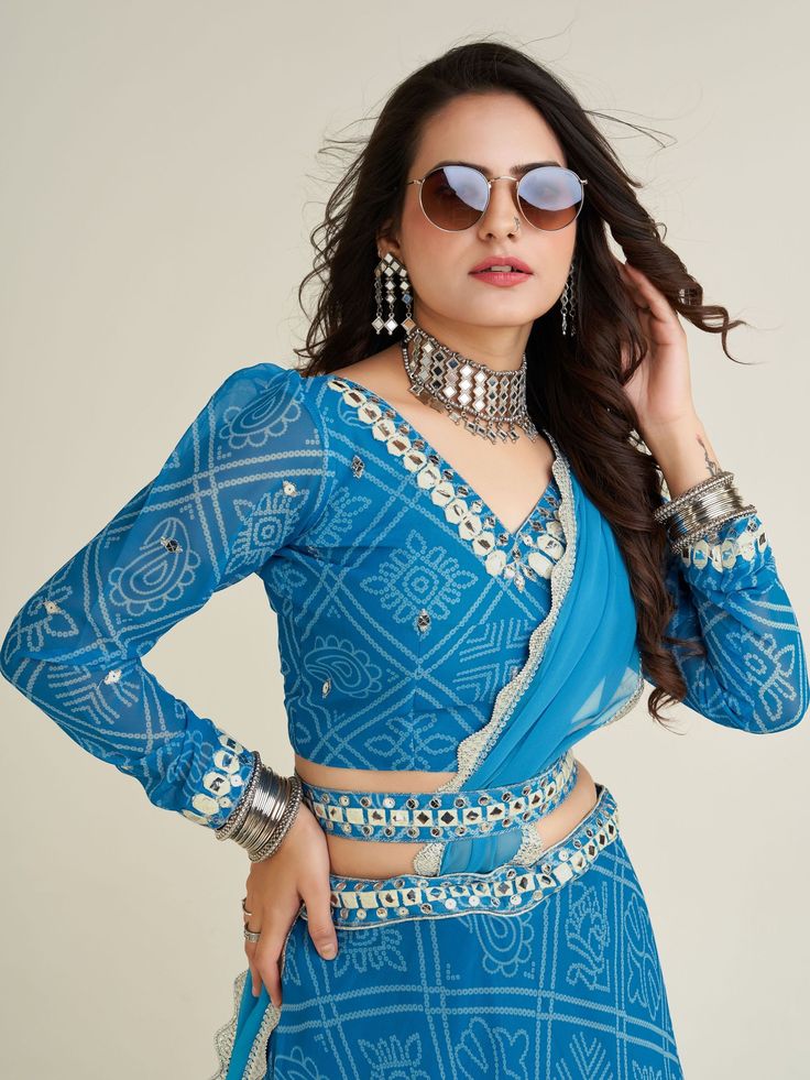 This beautiful sky-blue lehenga is perfect for festivals like Navaratri, special occasions, and weddings. The semi-stitched lehenga comes in a sky-blue color with bandhani print work, intricate thread, paper mirror, and sequin work on the waist.
The set includes a similar color georgette choli with bandhani print work, thread work, paper mirror, and sequins work, as well as a matching georgette dupatta with border work.
This lehenga choli set is its versatility. It can be dressed up for a festiv Blue Bandhani Print Blouse Piece For Festivals, Blue Bandhani Print Blouse Piece For Diwali, Blue Bandhani Print Blouse For Diwali, Traditional Blue Bandhani Print Blouse Piece, Blue Blouse Piece With Bandhani Print, Traditional Blue Blouse Piece With Bandhani Print, Bollywood Turquoise Saree Set, Turquoise Fitted Saree With Zari Work, Turquoise Bollywood Blouse Piece With Dupatta